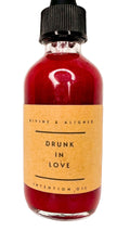 Bottle of 'Drunk in Love' intention oil with a brown label on a white background